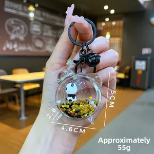 Macro detail of acrylic panda liquid quicksand keychain with black bell and gold stars