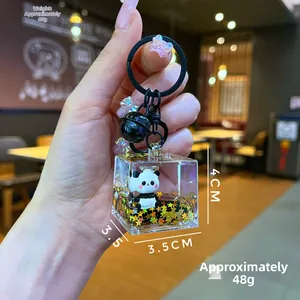 Macro shot of liquid panda keychain with golden stars and black bell detail