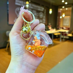 Détail d'un porte-clés Capybara à sables mouvants avec étoiles et cloche dorée