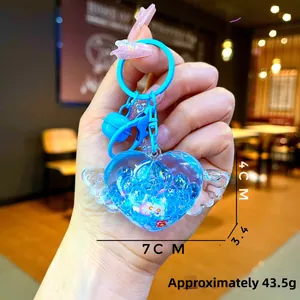 Detail of blue heart wing keychain with glitter resin and size labels of 4cm by 7cm
