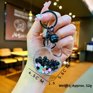 Detail of acrylic heart keychain with black beads and flower glitters, 5.6x4.5cm size