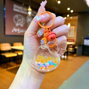 Acrylic heart quicksand keychain with yellow beads, floral sequins and red bell charm