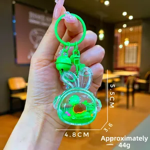 Detail of cute green turtle inside a rabbit-shaped liquid acrylic keychain with charms