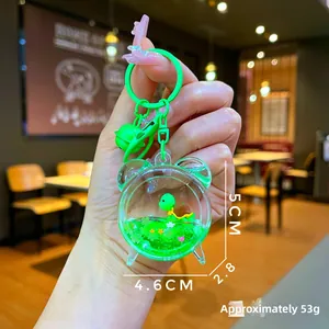Detail of cute green turtle liquid shaker keychain in alarm clock acrylic bottle