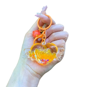 Porte-clés cœur ailes d'ange orange avec sable mouvant pailleté et petite clochette