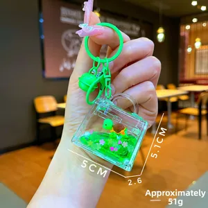 Close-up of turtle liquid glitter keychain with green oil and small bell charm
