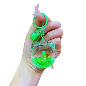 Green turtle floating keychain with moving glitter sand in a clear round charm