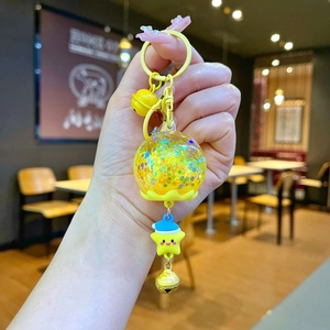 Détail d'un porte-clés jaune avec boule à paillettes et pendentif étoile mignonne