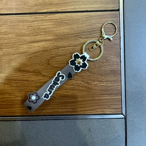 Close-up of Sakura silicone strap keychain with gold lobster clasp and floral charms