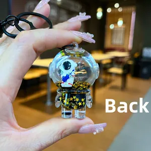 Back view of liquid-filled astronaut keychain with floating gold star sequins and metal ring