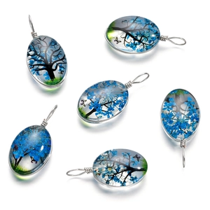 Détail de six pendentifs en verre faits main avec fleurs séchées bleues et motif de papillon