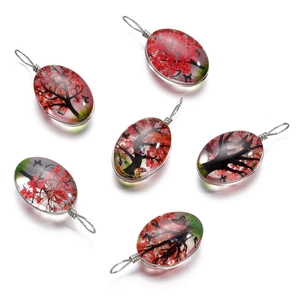 Détail de pendentifs Arbre de Vie avec fleurs séchées rouges et fil d'argent torsadé