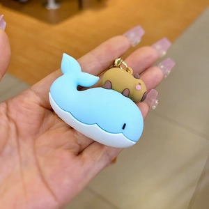 Detail of the blue whale and brown capybara silicone keychain with gold metal clasp