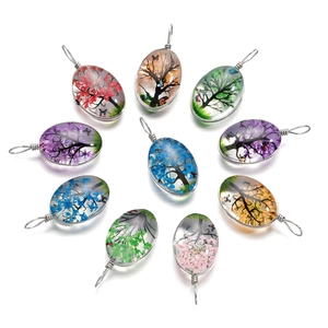 Vue macro de pendentifs en résine ovales avec fleurs séchées et fil d'argent