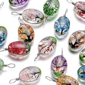 Vue détaillée de pendentifs arbre de vie artisanaux en verre et fil d'argent