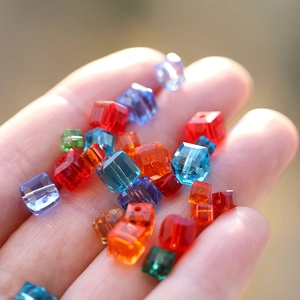 Colorful 8mm faceted crystal cube beads for DIY jewelry making held in palm of hand
