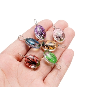 Détail de six pendentifs arbre de vie faits main avec fleurs séchées colorées et fil d'argent