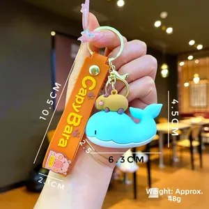 Detailed view of Capybara keychain with blue whale pendant and orange silicone strap