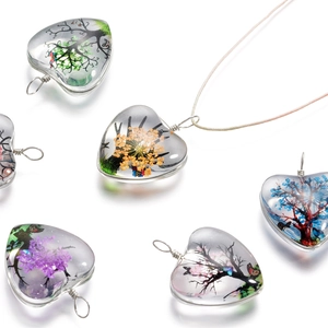 Gros plan de pendentifs en verre en forme de cœur avec l'arbre de vie coloré