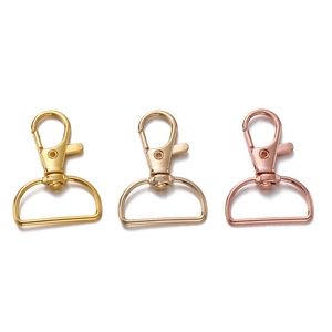 Detail van 25mm karabijnsluitingen in goud en roségoud met D-ringen voor tassen