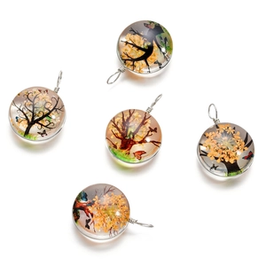 Détail macro de pendentifs en verre faits main avec fleurs séchées et arbre de vie