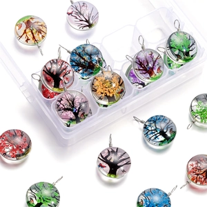 Détail des pendentifs arbre de vie en verre et papillons dans une boîte de rangement