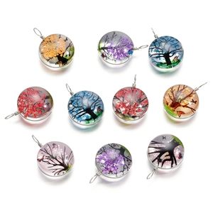 Gros plan de pendentifs ronds arbre de vie en verre avec fleurs séchées colorées