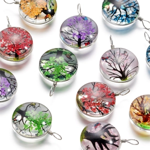 Vue détaillée de pendentifs en verre arbre de vie avec papillons colorés et fils métal