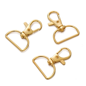 Detail van drie 25mm gouden karabijnsluitingen met D-ring voor DIY-sleutelhangers
