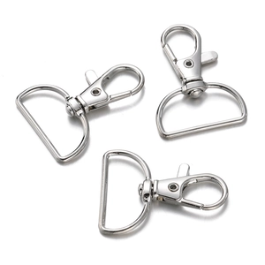 Gedetailleerde macro-opname van drie zilveren karabijnsluitingen met D-ringen voor sleutelhangers