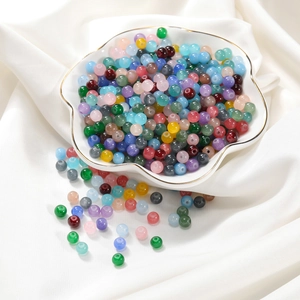 Vue macro de perles en verre poli coloré dans un plateau en céramique pour DIY