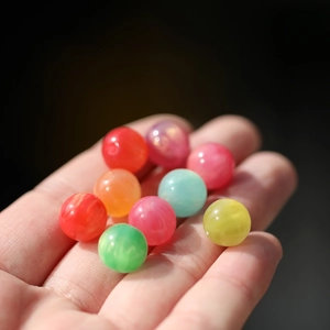 Makroaufnahme von 8/10mm bunten Kunstharzperlen mit Wolkentextur für DIY Schmuck