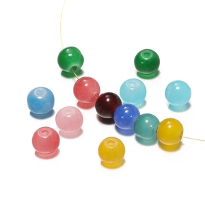 Gros plan de perles de verre translucides colorées sur fil doré pour bijoux DIY