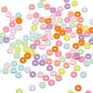 Flat colorful plastic round spacer beads scattered on white background for DIY crafts