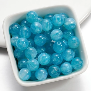 Dettaglio di perle rotonde in resina blu cielo con glitter per creare gioielli DIY