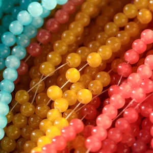 Vue macro de perles en verre œil-de-chat colorées pour bracelets avec un lustre soyeux