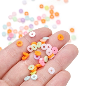 Colorful macaron polymer clay spacer beads held by hand for DIY jewelry making
