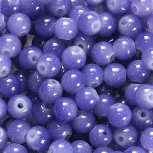 Vue macro de perles rondes en verre violet lavande avec une texture minérale douce