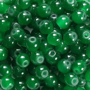 Gros plan macro de perles en verre vert foncé translucide pour bijoux DIY avec éclat
