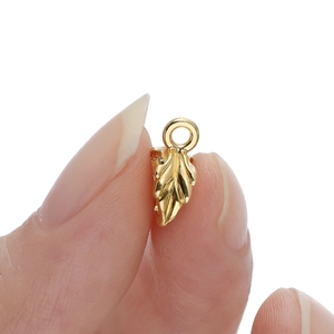 Macro detail of golden leaf pendant showing intricate vein texture and size scale