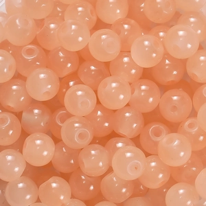 Gros plan de perles en verre orange rose poli pour la création de bijoux DIY