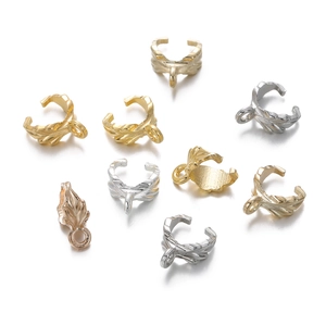 Close-up of alloy leaf pendants with detailed feather texture in gold and silver finishes