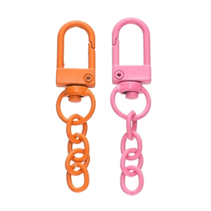 Detail von bunten Legierungskarabinerhaken in Orange und Pink mit Gliederketten