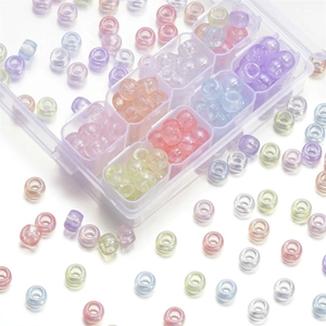 Nahaufnahme irisierender Acrylperlen in verschiedenen Farben in einer transparenten Box