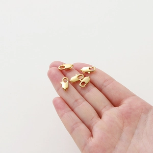 5 goldene Karabinerverschlüsse auf Fingerspitzen zur Größenanzeige für DIY-Schmuck