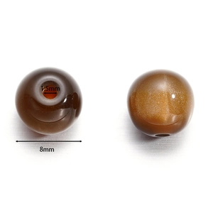 Macro detail of 8mm brown cat-eye resin beads showing the 1.5mm center hole for DIY jewelry