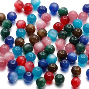 Macro detail of multi-colored resin cat-eye beads with smooth finish and central drill holes