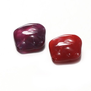 Close-up of irregular marbled acrylic beads in deep purple and bright red for DIY jewelry