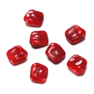 Close-up of translucent red acrylic irregular square beads with marble texture for DIY