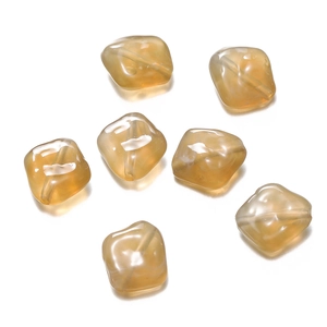 Macro view of amber acrylic irregular beads with natural texture for DIY jewelry making